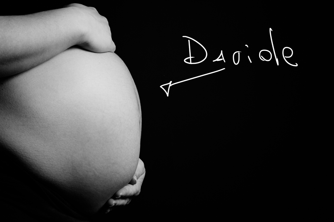 Aspettando Davide Immagine in bianco e nero di una pancia incinta con una mano che la sostiene, accompagnata dalla scritta "Dariole". Rappresenta la dolce attesa e la connessione tra madre e bambino.