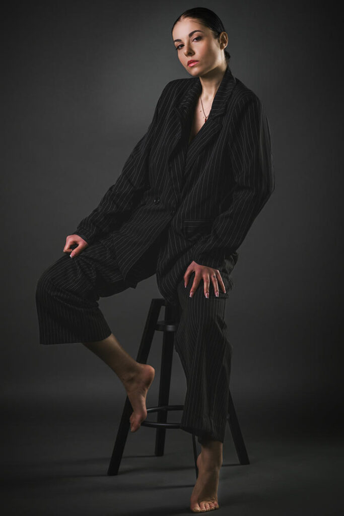 Tailored Silence ritratto fotografico in studio di Maka Strazzullo con completo nero e posa minimale